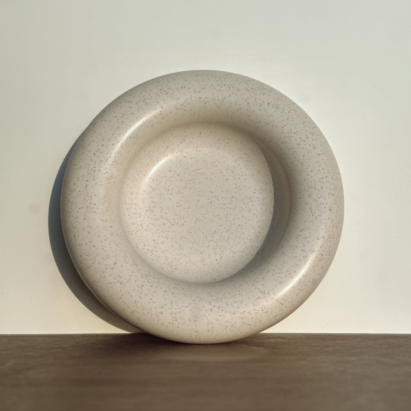 Plateau décoratif Halo en Jesmonite, au design circulaire et finition minérale mouchetée.